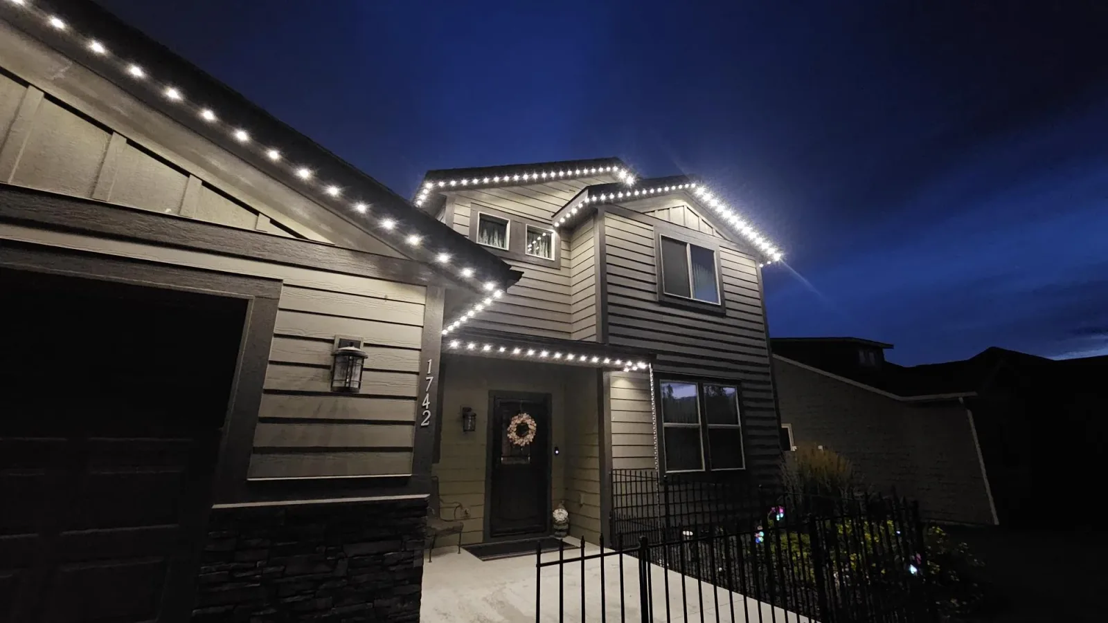 Home outlined in warm white permanent LED roofline lighting at night